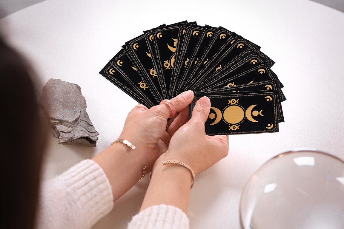 Soothsayer with Tarot Card at Table, Closeup
